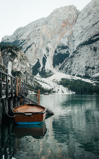 白天在山附近水面上的棕色木船